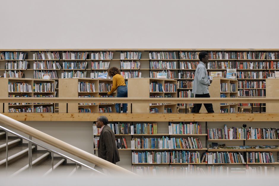 A warm, atmospheric library interior featuring a prominent central globe and study tables.
