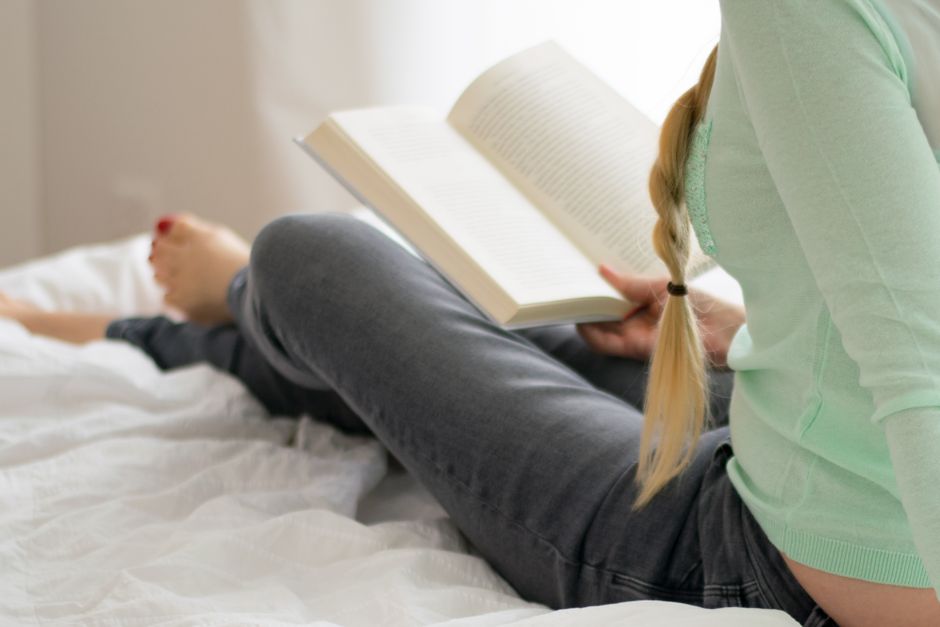 Woman relaxing with magazines in a stylish, cozy living room with contemporary decor.